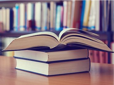 An open book stacked on two other books