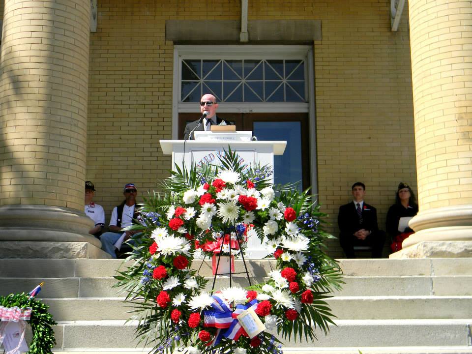 Man speaking at white podium