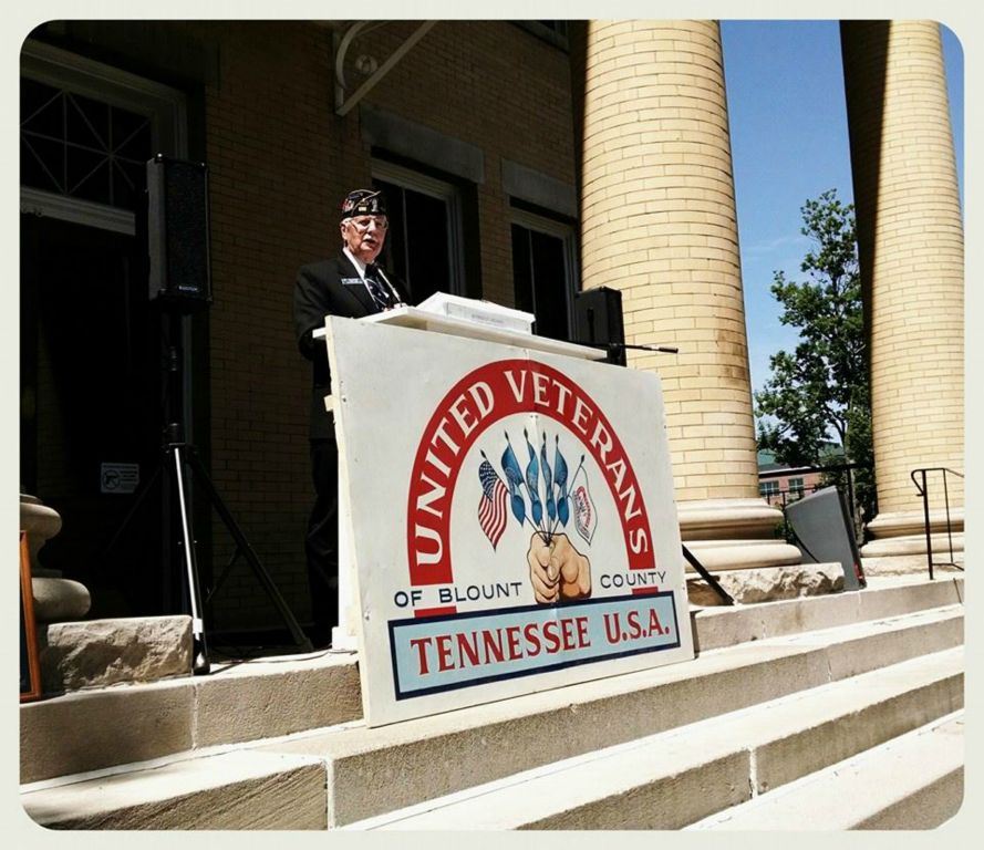 Speaker standing at podium at top of Court House stairs
