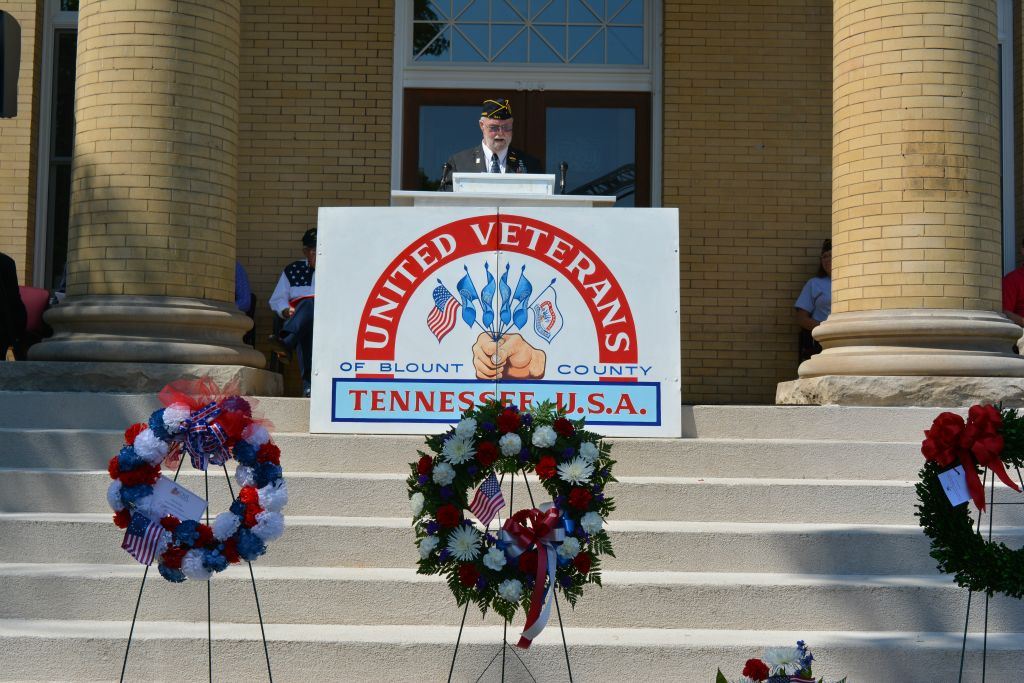 Speaker at podium at top of Court House steps