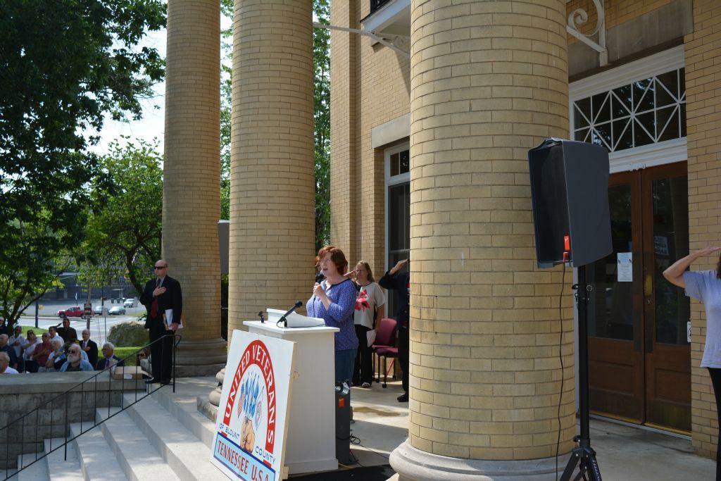 Speaker at podium at top of Court House steps