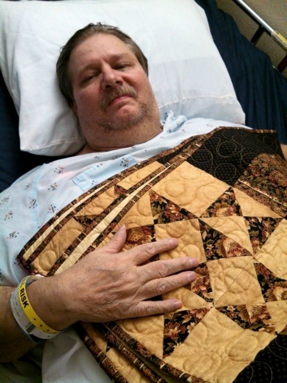 Man in hospital bed with yellow quilt