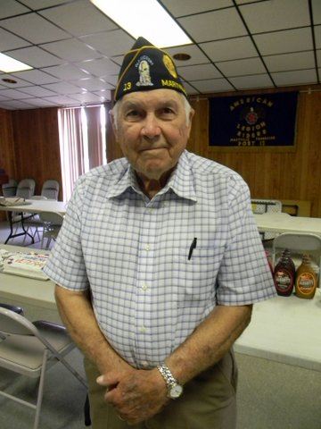 Man wearing Korean war uniform hat, standing with arms together in front of his body