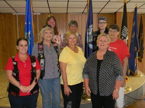 Eight women standing with each other, looking into the camera smiling