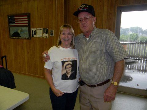 Man with arm aroun dwoman's shoulder, standing and smiling