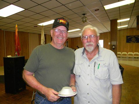 Two veterans standing beside each other, one with bowl in hand, both smiling