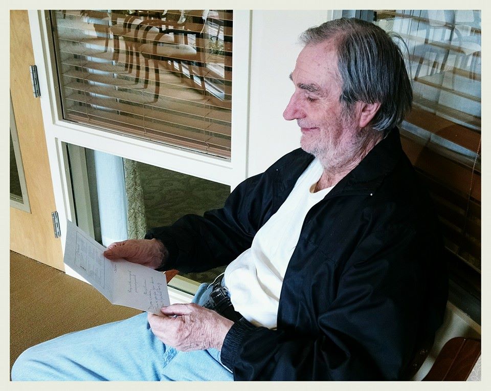 Sitting veteran smiles while reading card