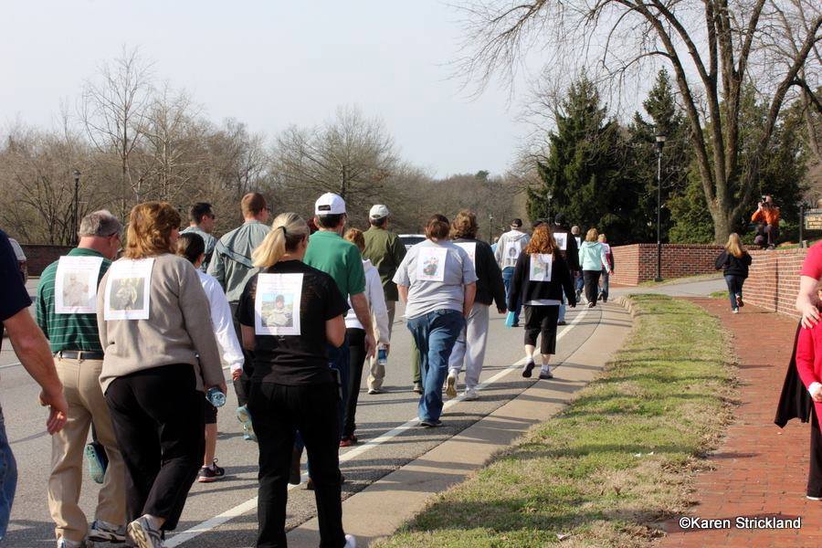 Facing away, group walks up street