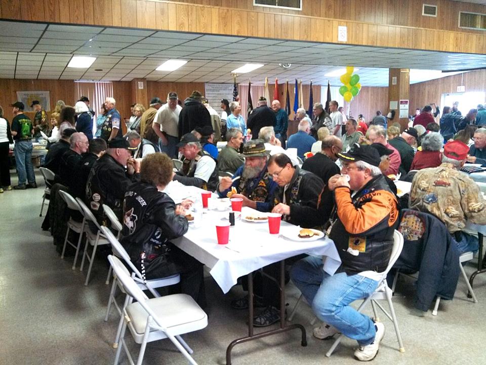 Large crowd sits at banquet hall eatign and some in line at the buffet