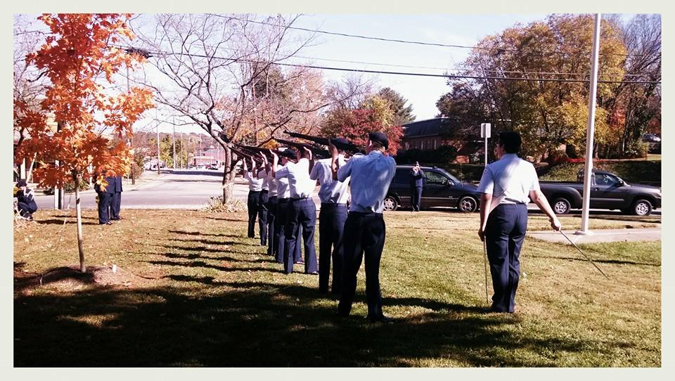 Line of cadets aim firearms, while standing in line 