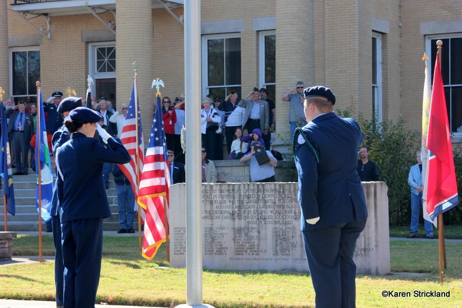 Three cadets saulte the American flag after rasing it on pole outside of Court house