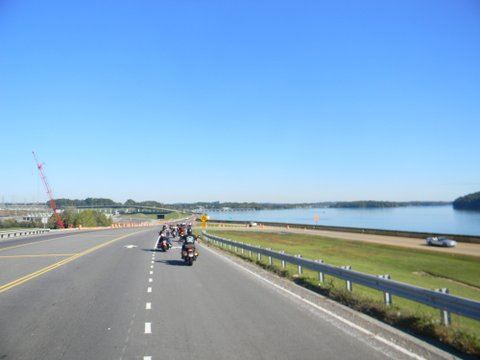 Image of motorcycles in front on road with grass on sides